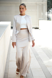 Woman in a white outfit walking in a modern architectural setting
